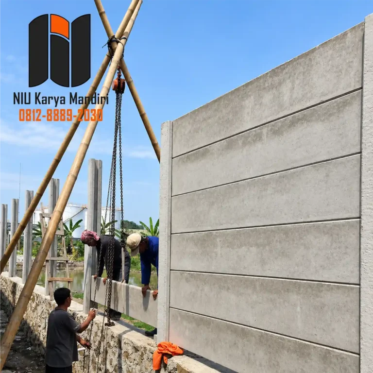 pekerja memasang paga penel beton menggunakan alat bantu